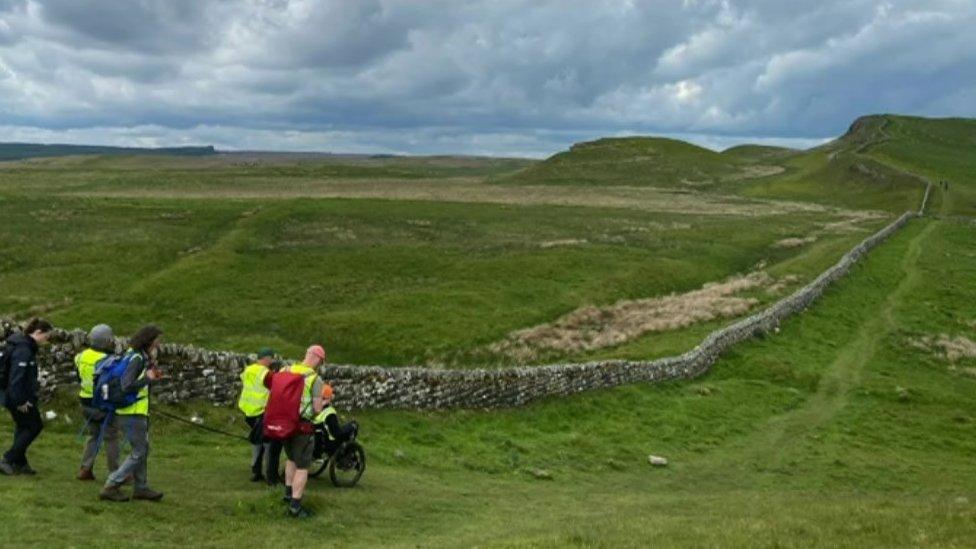 Brynn Hauxwell and his team pictured next to part of Hadrian's Wall