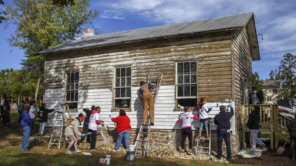 Volunteers painting over the graffiti