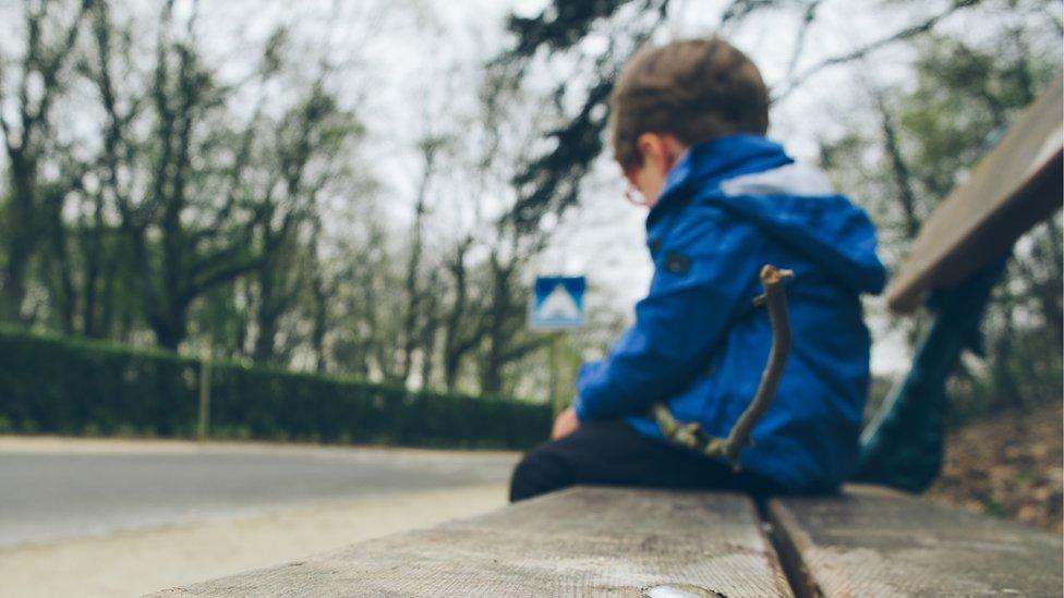 Boy sitting alone in park