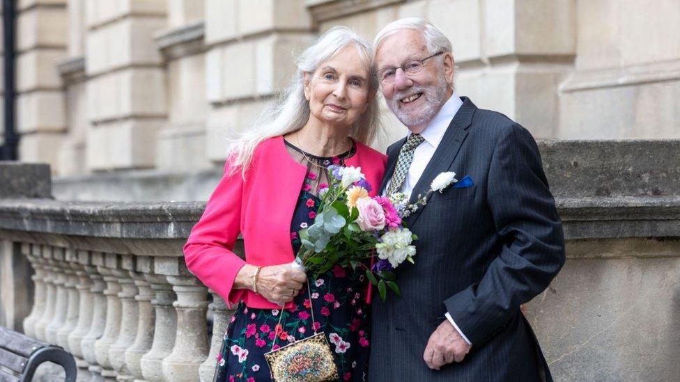 A woman in a pink jacket and a man in a suit