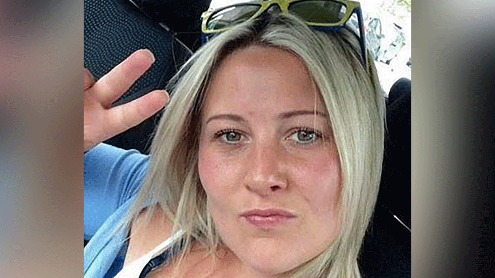 Joanne Penney holds up two fingers in a peace sign