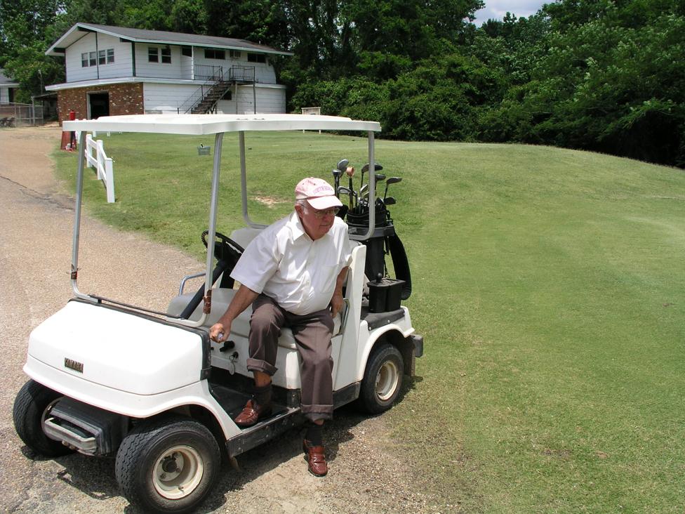 Donald today on a golf course, getting out of a golf buggy