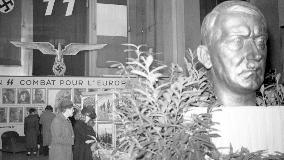 Exhibition of the French Waffen SS with a bust of Hitler. Paris, Champs-Elysées, January 1944