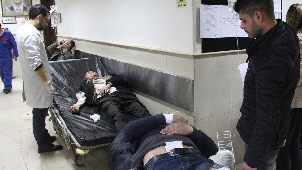 Injured men wait to receive medical treatment after being wounded in a suicide bomb attack at the Palace of Justice in Damascus (15 March 2017)