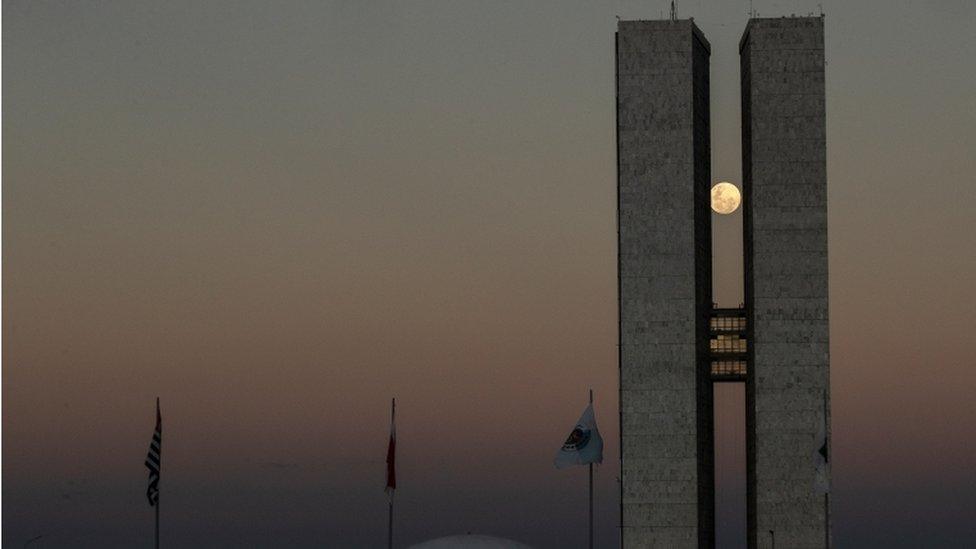 Staying in South America, this picture shows the super moon peaking between the two towers of the National Congress building, in Brasilia, Brazil.