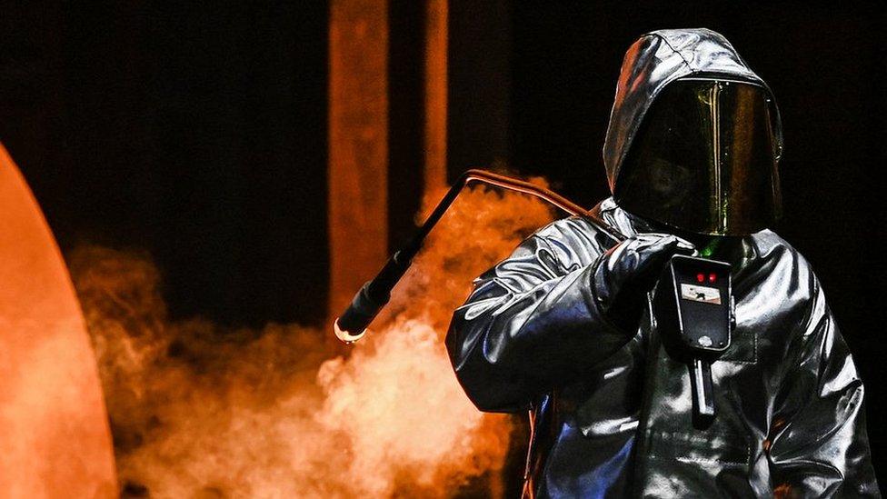 An employee takes a sample at the blast furnace at the ThyssenKrupp plant in Duisburg, western Germany