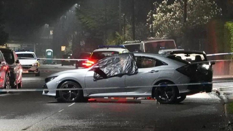A silver car in the aftermath of the crash which killed Marcia Grant, with a police cordon around it.