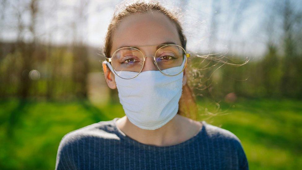 Woman wearing a face covering and glasses