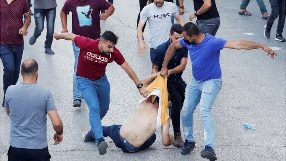 Palestinian plain clothed security officers detain a protester in Ramallah (26/06/21)