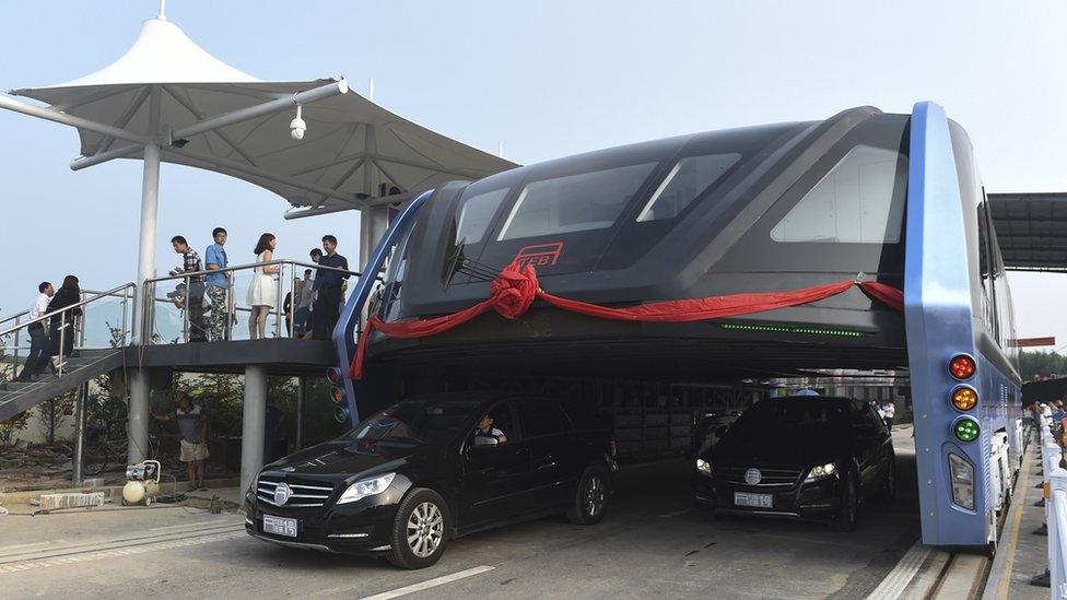 People stand on a platform as the Transit Elevated Bus TEB-1 conducting a test run after it unveiled in Qinhuangdao, north China's Hebei Province.