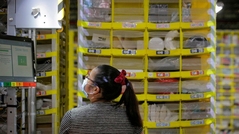 An employee fills a cart full of items at Amazon"s JFK8 distribution center in Staten Island, New York, U.S. November 25, 20