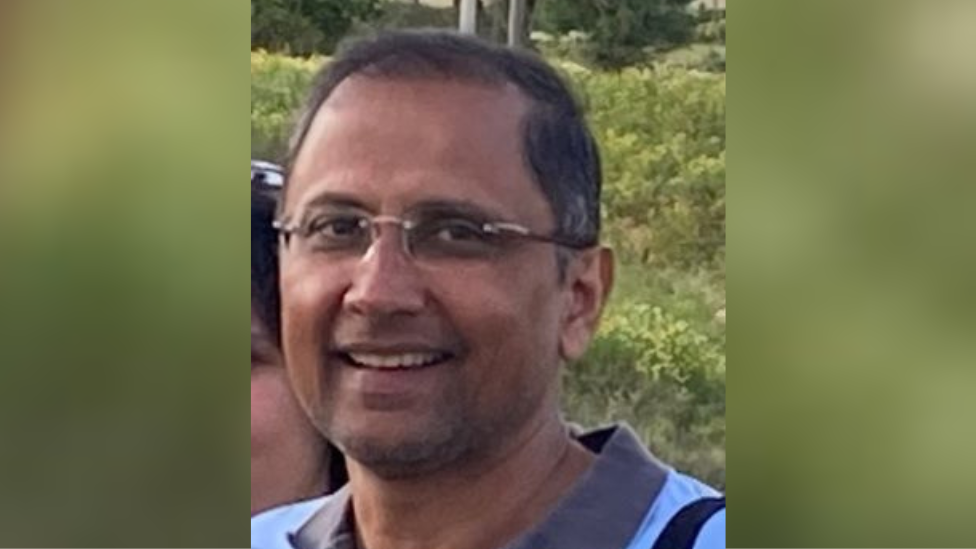 A close up of a smiling Ramaswamy Jayaram in glasses looking directly at the camera. 