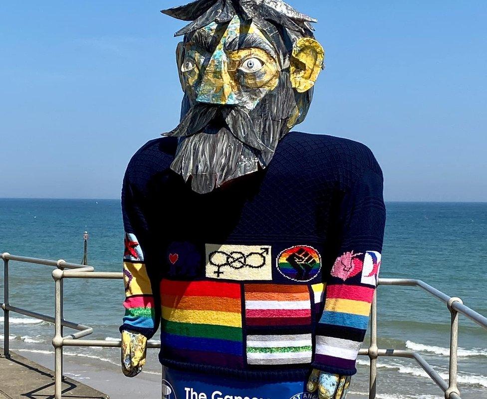 Gansey of inclusivity worn over puppet of a bearded man, standing on promenade at Sheringham