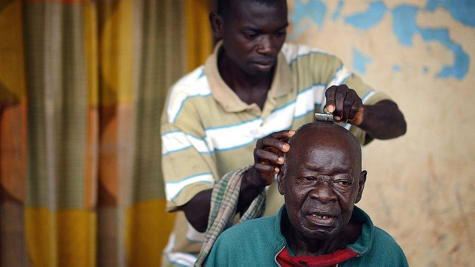 A man having his head shaved at a barbers in Ghana