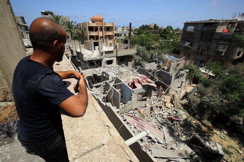 A man looks at the debris of a building in Khan Yunis, Gaza, on May 20, 2021