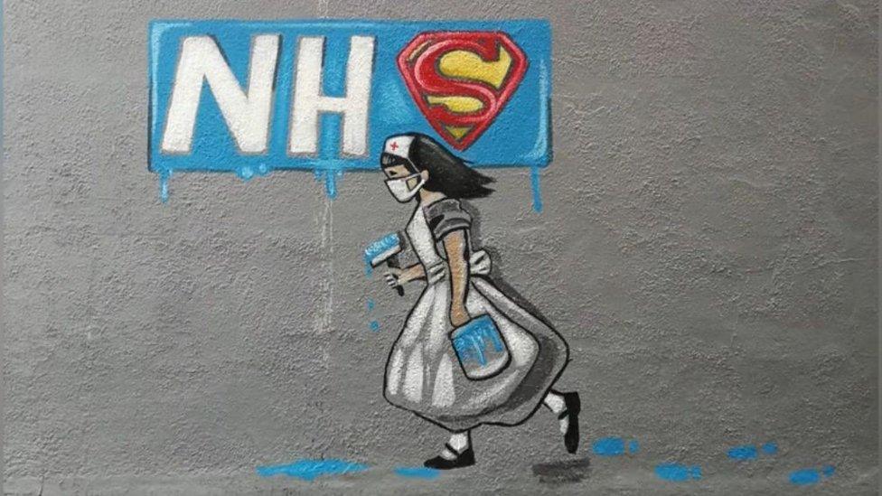 The wall art created by Rachel List showing a nurse with a mask and paintbrush and an NHS sign with the S being a Superman graphic style