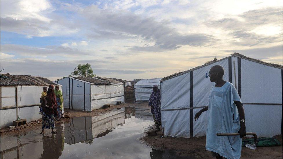 Mohammed Akdeef, an internally displaced farmer, speaks with people on July 21, 2019 at an informal settlement in Madinatu, Old Maiduguri