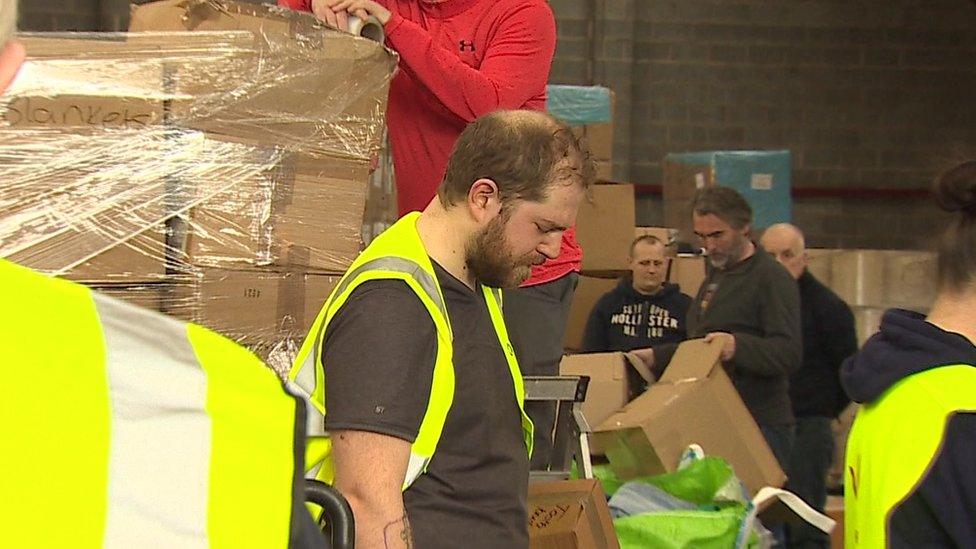 People in a warehouse bowing their heads