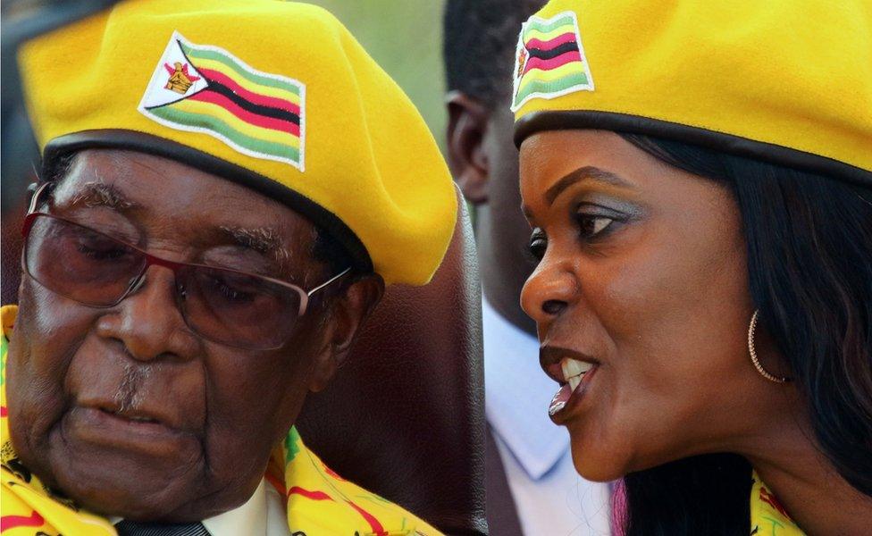 President Robert Mugabe listens to his wife Grace Mugabe at a rally of his ruling ZANU-PF party in Harare, Zimbabwe, November 8, 2017