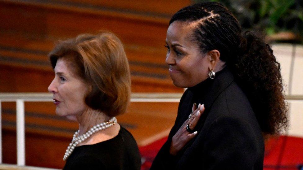 Laura Bush and Michelle Obama watch on at the memorial