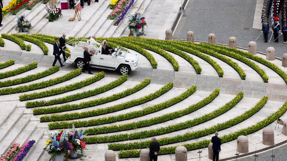 Pope waves from the back of the popemobile in the Vatican