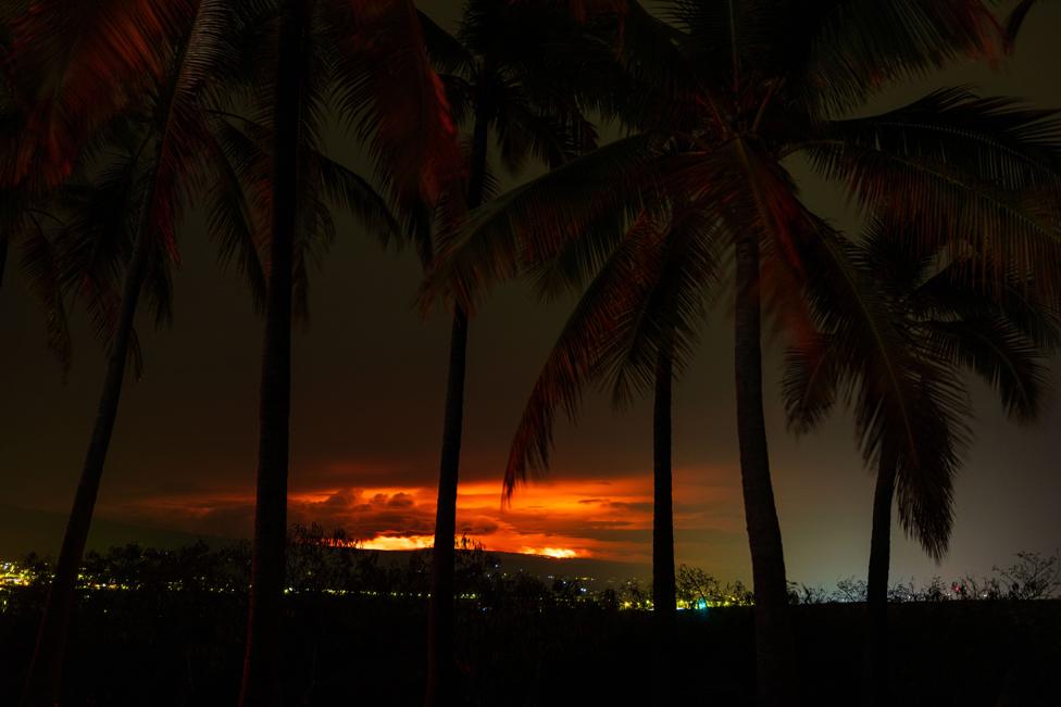 An intense glow is reflected off of clouds above the summit, in Kailua Kona, Hawaii, USA, 28 November 2022.