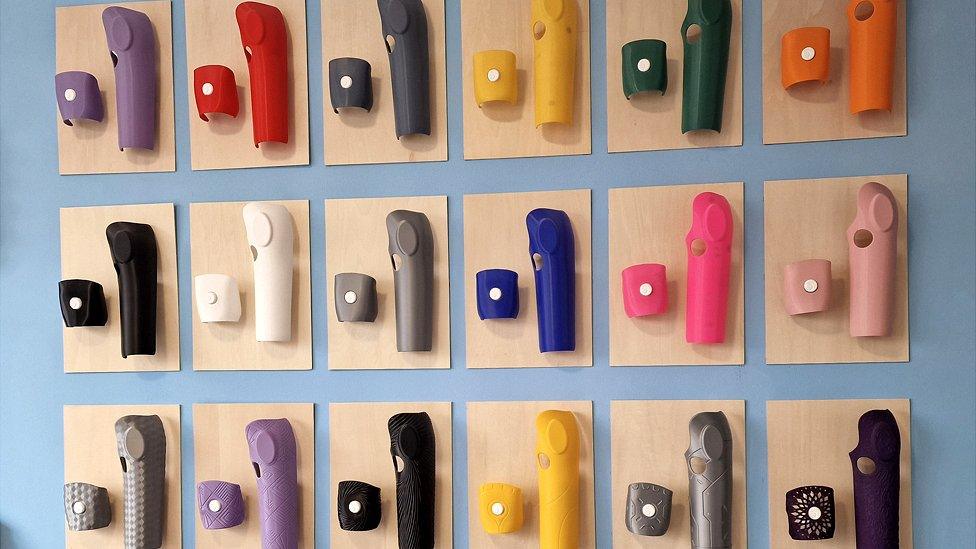 A wall of different coloured bionic arm cases