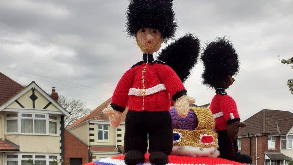 Knitted postbox topper of the Kings guards.