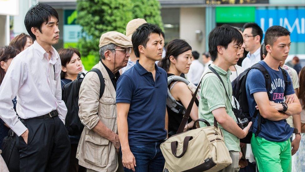 People in a electronics store in Tokyo, Japan, 08 August 2016 watch a TV screen broadcasting Japanese Emperor Akihito, 82, delivering a video message to the public.