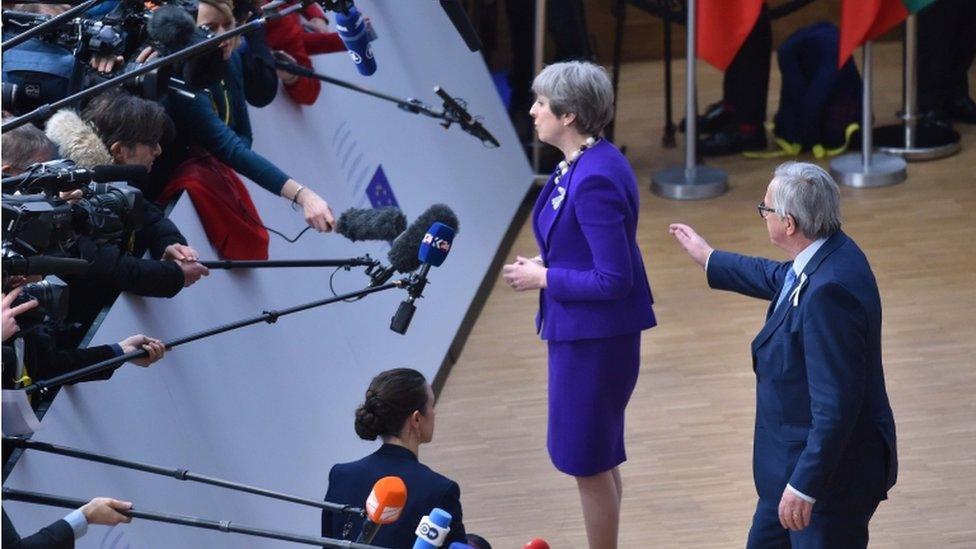 Jean-Claude Juncker approaches Theresa May at press conference