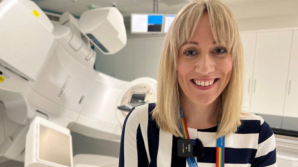 Lady smiling in front of hospital machine