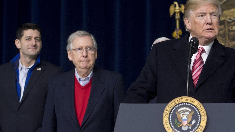 Paul Ryan and Mitch McConnell watch as Donald Trump speaks.