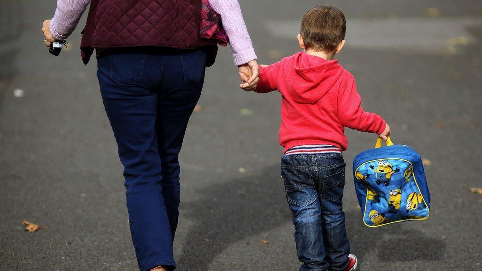 A woman holding a child's hand