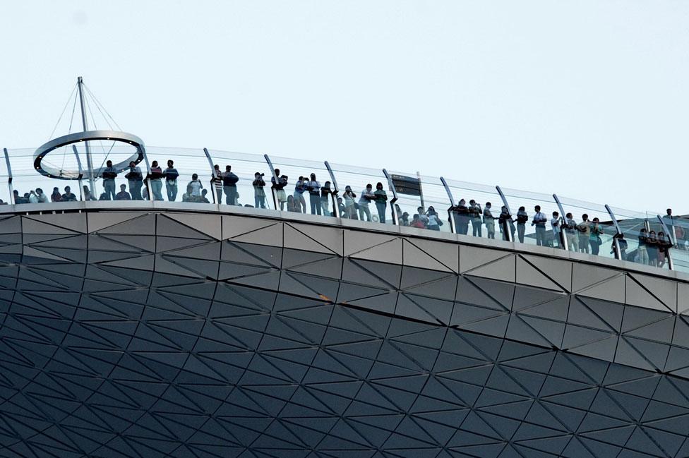 Visitors looking at the view from the skypark of the 55-storey hotel tower of Marina Bay Sands in Singapore, 26 August 2010