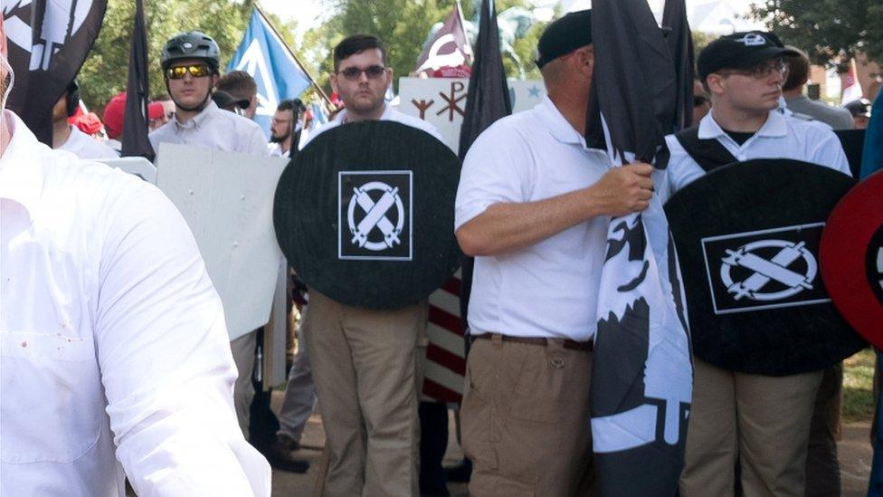 James Fields is pictured holding up a homemade shield with a logo of the Vanguard America group