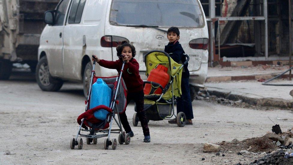 Children push containers in strollers as they flee deeper into the remaining rebel-held areas of Aleppo, Syria December 12, 2016