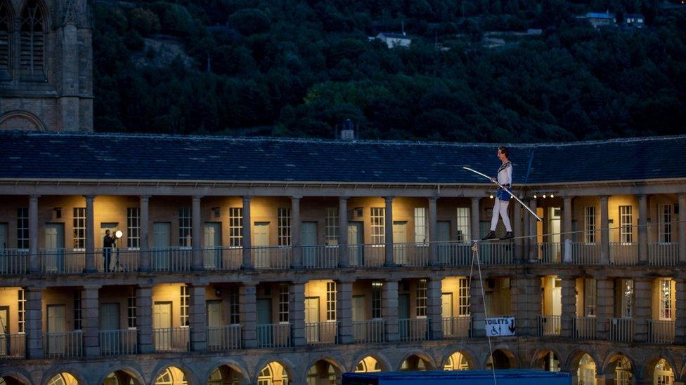 Man walking on a tightrope at The Piece Hall in Halifax