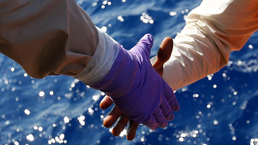 Migrants are helped to board on the Norwegian Siem Pilot ship during a migrant search and rescue mission off the Libyan Coasts, Tuesday, Sept. 1, 2015