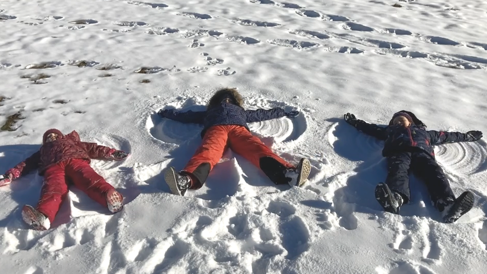 The Crewe family children make snow angels