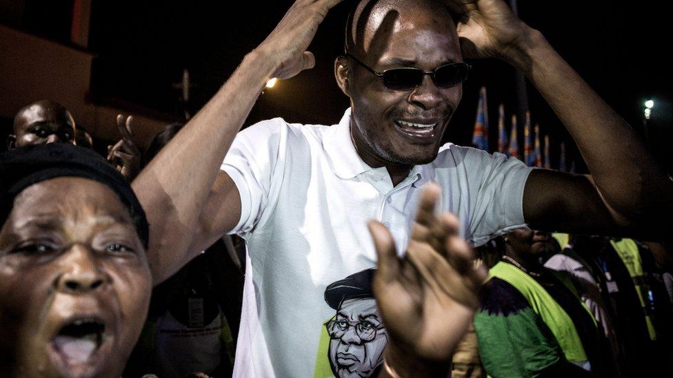 Supporters react as the coffin containing the remains of former Congolese Prime Minister and opposition leader Etienne Tshisekedi arrives from Belgium