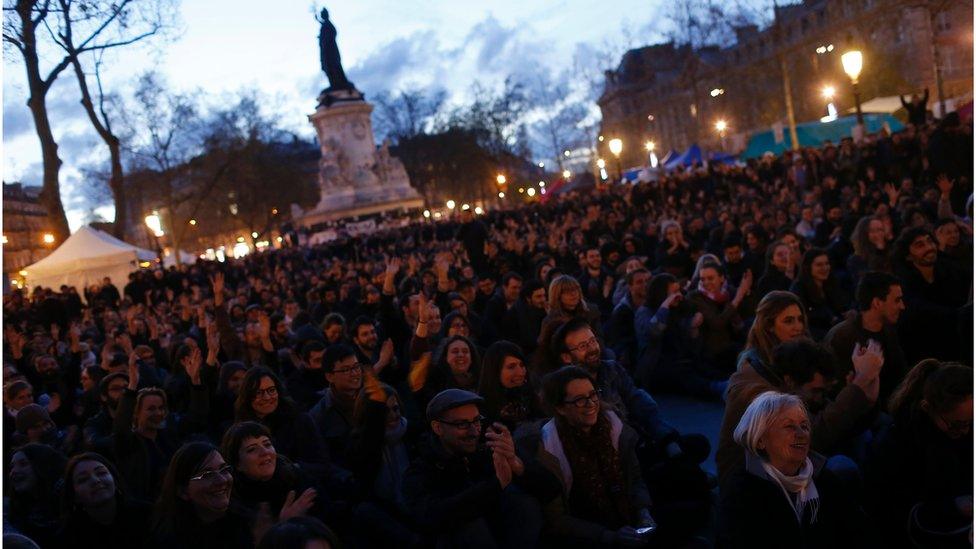 People listen to a speech during a gathering by the 'Nuit Debout' movement on Place de la Republique in Paris