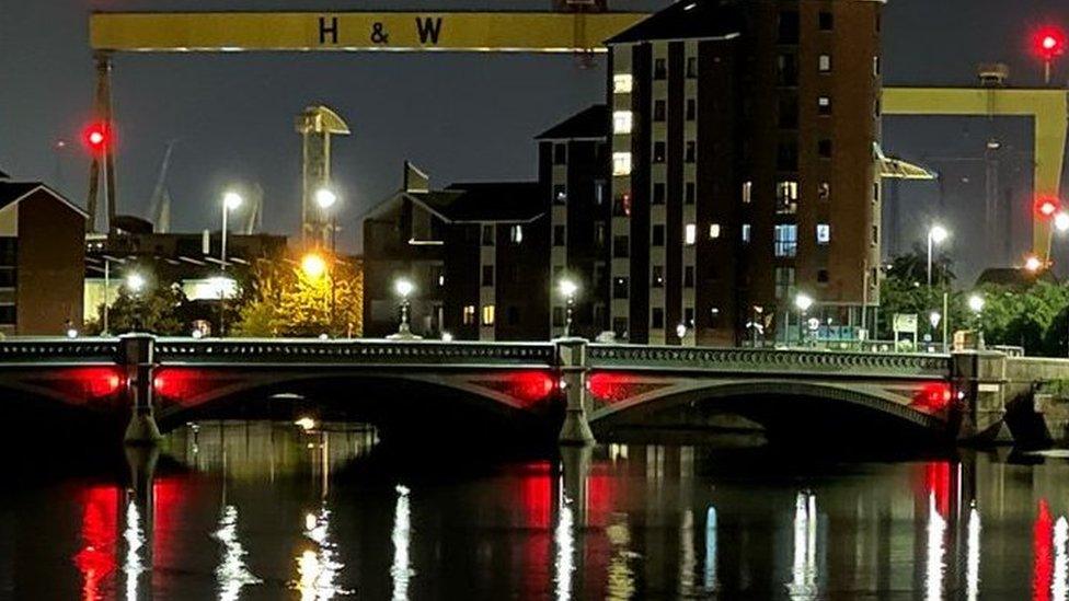 red light filters fitted to flood lighting on the arch of the bridge