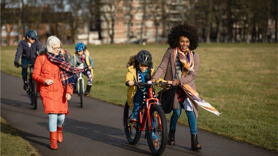 family-cycling-through-park