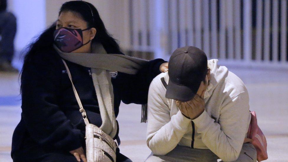 People grieve outside the nightclub in Lima where 13 people were killed in a crush on 22 August 2020