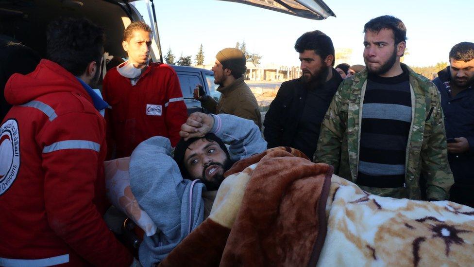 A wounded Syrian, who was evacuated from rebel-held neighbourhoods in the embattled city of Aleppo, is put into the back of an ambulance upon his arrival in the opposition-controlled Khan al-Assal region, west of the city