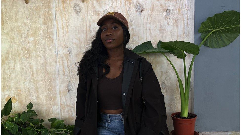 Alvina Appleton in front of wall and plants