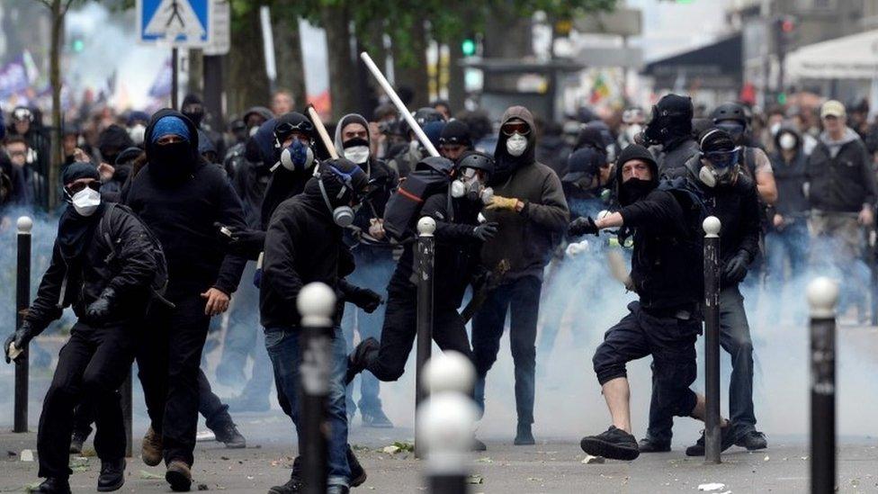 Demonstrators clash with police officers during a protest against proposed labour reforms in Paris, 14 June