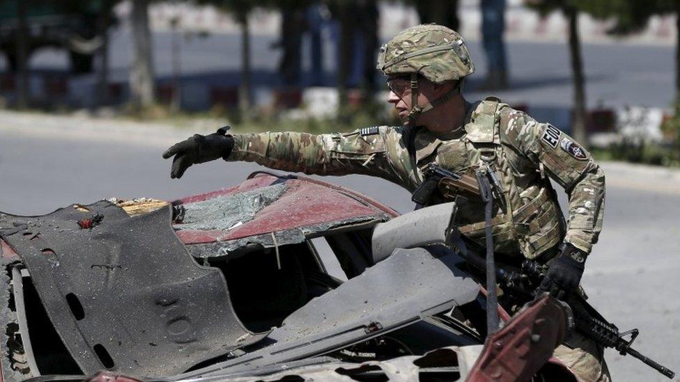 A US soldier inspects the site of a suicide bomb attack in Kabul (30 June 2015)