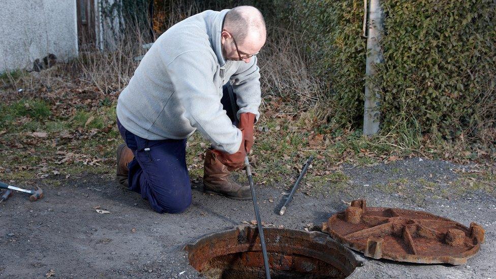 Man poking a drain