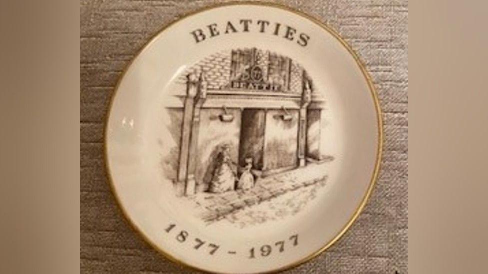 place embossed with black and white drawing of beatties store